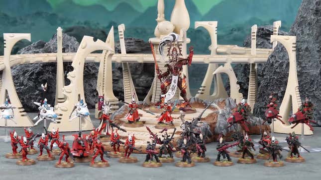 A collection of Warhammer 40,000 Aeldari models, placed on a diorama of alien structures.