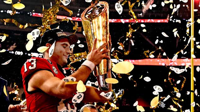 Georgia quarterback Stetson Bennett holds up the championship trophy after defeating the TCU Horned Frogs 65-7 to win the CFP National Championship.