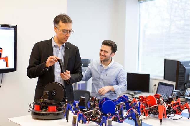 Dalloro holding a plastic object built by the bots.