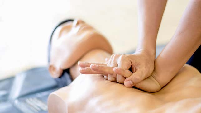 Person practicing CPR on a dummy