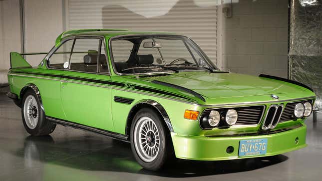A photo of a green BMW 3.0 CSL in a studio. 