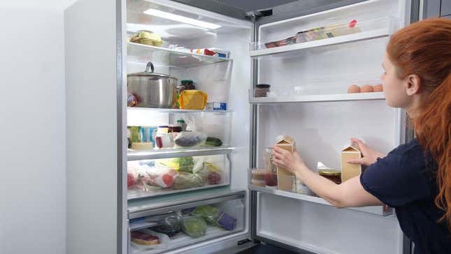 Person storing food on refrigerator door