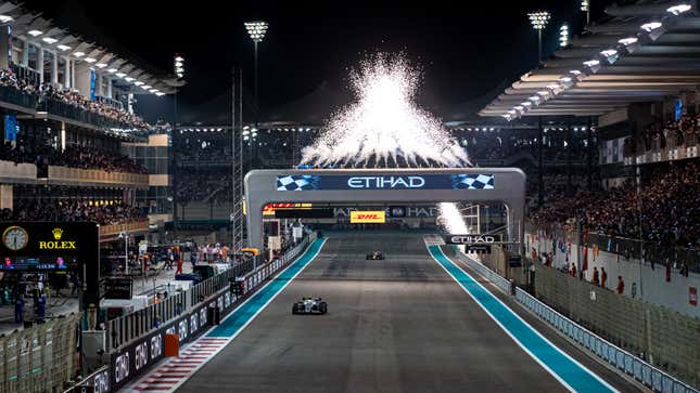 A photo of Max Verstappen crossing the finish line in Abu Dhabi as fireworks go off. 