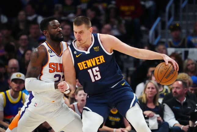 May 1, 2023; Denver, Colorado, USA; Denver Nuggets center Nikola Jokic (15) drives at Phoenix Suns center Deandre Ayton (22) in the first quarter during game two of the 2023 NBA playoffs at Ball Arena.