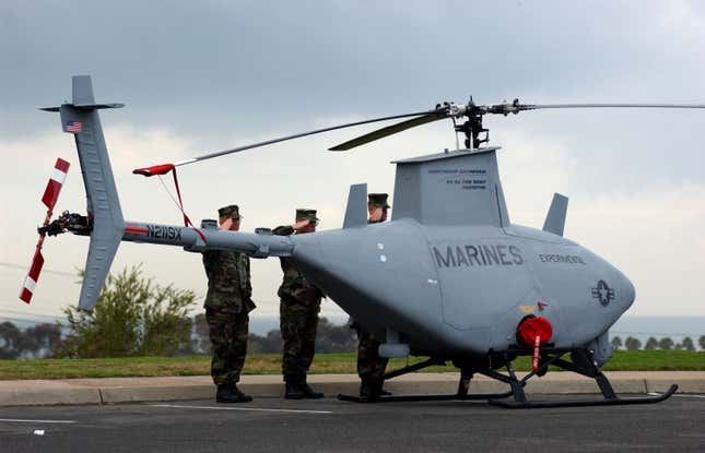 US Marines salute near a Northrop Grumman RQ-8A Fire Scout prototype  unmanned helicopter during the playing of the National Anthem at the 7th  annual Marine West 2002 Military Exposition, January 16, 2002, at Camp  Pendleton, CA