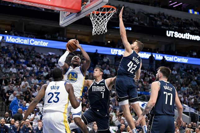 Mar 22, 2023; Dallas, Texas, USA; Golden State Warriors forward Kevon Looney (5) shoots over Dallas Mavericks center Dwight Powell (7) and forward Maxi Kleber (42) and guard Luka Doncic (77) during the first quarter at the American Airlines Center.