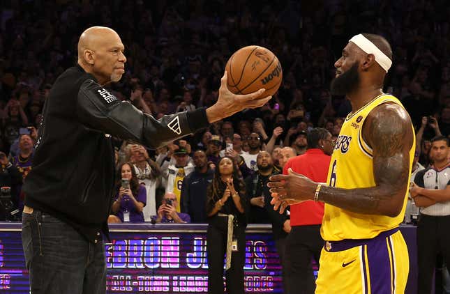 Kareem Abdul-Jabbar hands LeBron James the ball after James passed Abdul-Jabbar to become the NBA’s all-time leading scorer on Feb. 7, 2023, in Los Angeles.