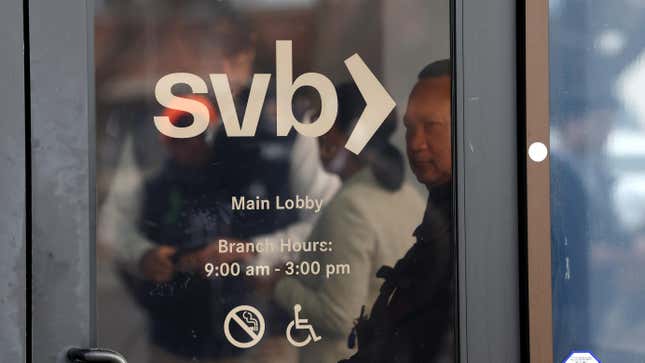 : A security guard at Silicon Valley Bank monitors a line of people outside the office on March 13, 2023 in Santa Clara, California. Days after Silicon Valley Bank collapsed, customers are lining up to try and retrieve their funds from the failed bank. 