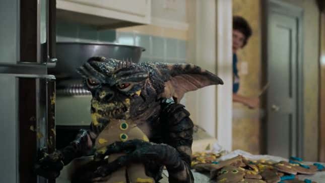An evil Gremlin munches on a Christmas cookie in a scene from Gremlins.