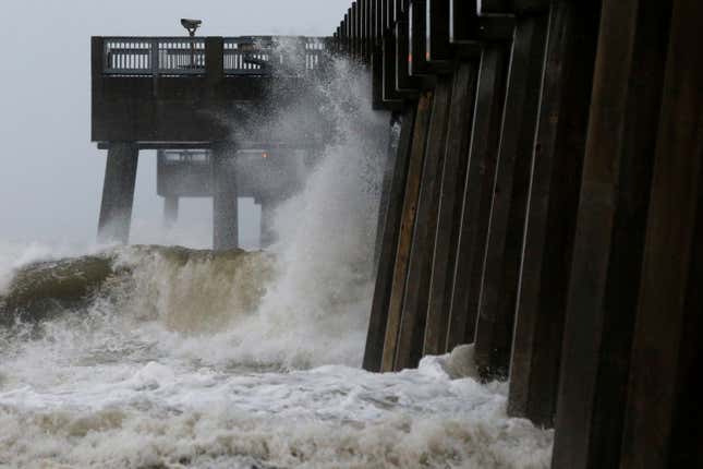 Waves crash along a pier in Panama City Beach.