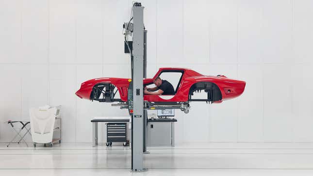 A photo of the Bizzarrini continuation car on a lift in the factory.