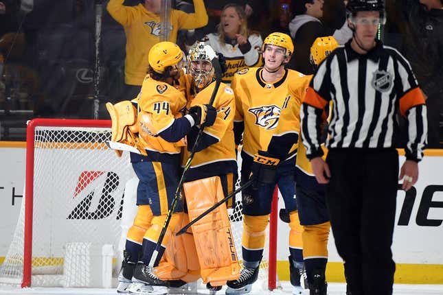Apr 6, 2023; Nashville, Tennessee, USA; Nashville Predators goaltender Juuse Saros (74) is congratulated by left wing Kiefer Sherwood (44) and defenseman Cal Foote (52) after a shutout win against the Carolina Hurricanes at Bridgestone Arena.