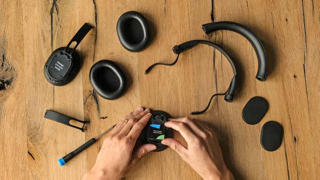 The black speckled version of the Fairphone XL headphones disassembled on a wooden table.