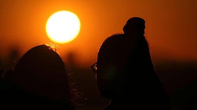 A couple watches the sun set, on May 13, 2023, as seen from the 520 Bridge View Park in Washington during a heat wave. 