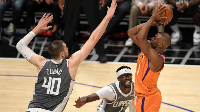 Chris Paul of the Phoenix Suns shoots against Ivica Zubac and Reggie Jackson of the LA Clippers.