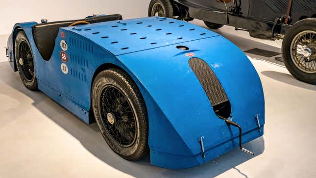A photo of a vintage Bugatti race car in a museum. 