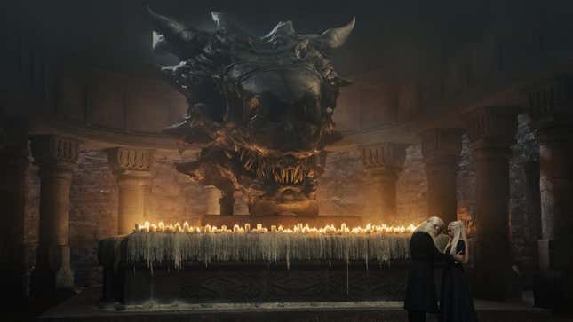A dragon skull looms behind a row of candles, with two Targaryens in front of it.