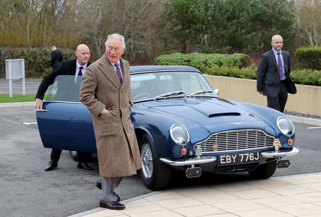 Prince Charles in front of his vintage Aston Martin car