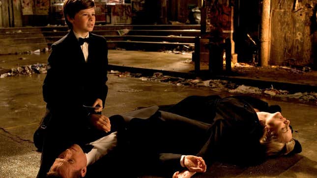 The bodies of Thomas and Martha Wayne on the ground, with future Batman Bruce Wayne grieving over them.