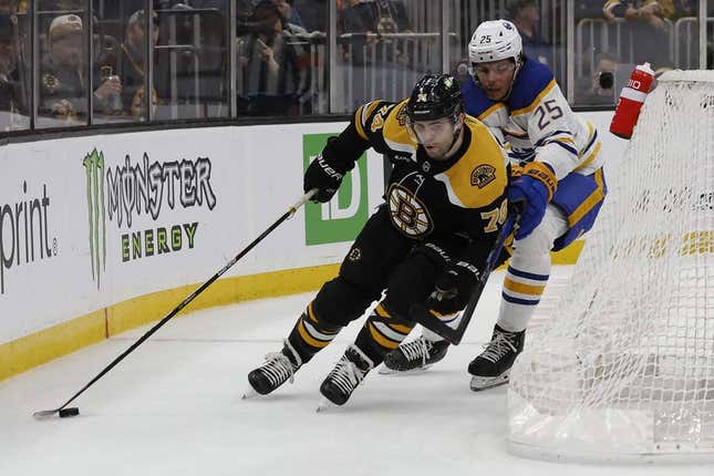 Mar 2, 2023; Boston, Massachusetts, USA; Boston Bruins left wing Jake DeBrusk (74) swings behind the net with Buffalo Sabres defenseman Owen Power (25) checking him during the first period at TD Garden.