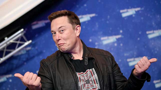 A photo of Elon Musk making a funny face and hand gesture at an event.