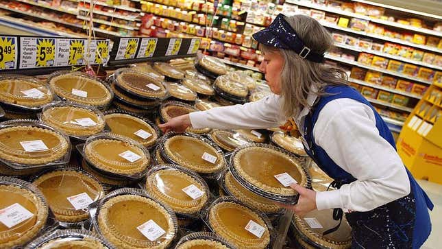 Grocery store worker stocking Thanksgiving pumpkin pies