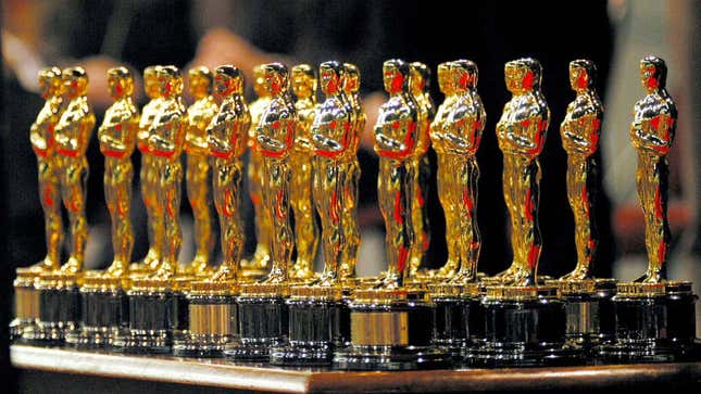 A bunch of Oscar awards, lined up in rows.