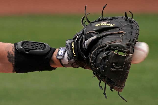 A catcher wears a PitchCom wristband.