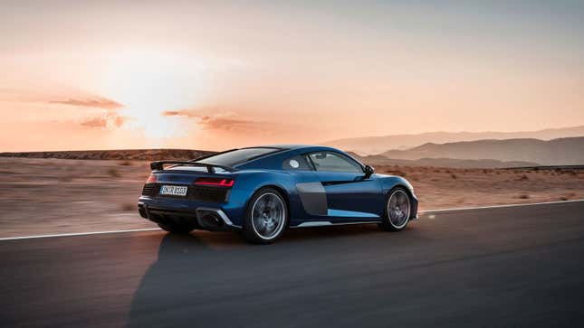 A photo of a blue Audi R8 supercar at sunset. 