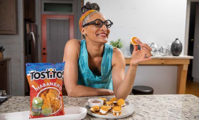Chef Carla Hall holding up a Spicy Tostitos S'more above a plate full of s'mores [image provided by Frito-Lay]