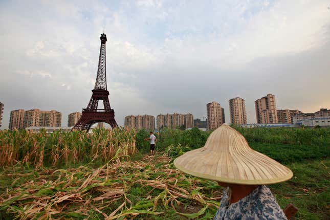 A farmer passes a replica of the Eiffel Tower in Tianducheng.