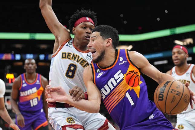 Mar 31, 2023; Phoenix, Arizona, USA; Phoenix Suns guard Devin Booker (1) dribbles against Denver Nuggets forward Peyton Watson (8) during the first half at Footprint Center.