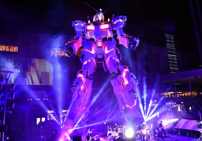 Musicians perform at the base of a life-sized Gundam statue in Tokyo.