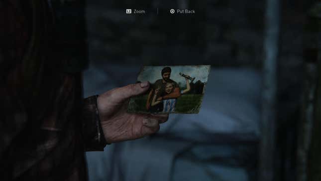 Joel holds a photo of himself with his daughter Sarah in a moment from the game The Last of Us.