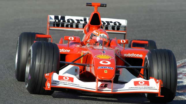 A photo of Michael Schumacher driving his 2003, red Ferrari F1 car. 