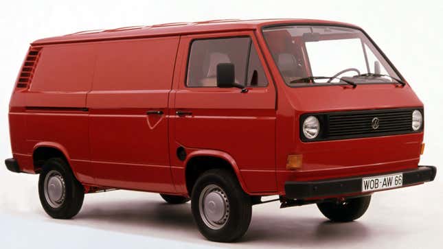 A photo of a red VW Van from the 1970s in a studio. 