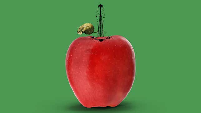 An photo illustration showing an oil well coming out of an apple on a green background.