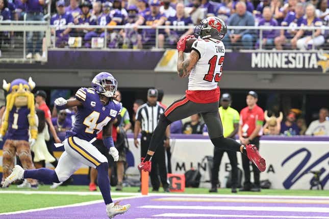 Sep 10, 2023; Minneapolis, Minnesota, USA; Tampa Bay Buccaneers wide receiver Mike Evans (13) catches a touchdown pass from quarterback Baker Mayfield (not pictured) as Minnesota Vikings safety Josh Metellus (44) defends during the second quarter at U.S. Bank Stadium.