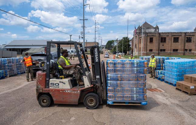 A member of the National Guard delivers palettes of water on a fork-lift at the State Fair Grounds in Jackson, Mississippi, on September 2, 2022