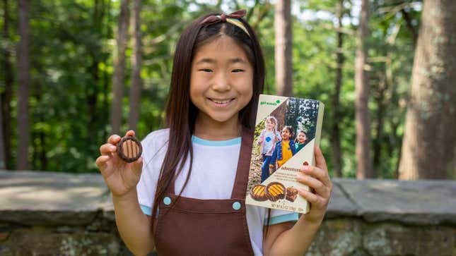 Girl Scout holding box of Adventurefuls Girl Scout Cookies