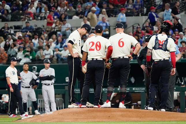 Apr 28, 2023; Arlington, Texas, USA; Texas Rangers starting pitcher Jacob deGrom (48) is visited on the mound by teammates and pitching coach pitching coach Mike Maddux (31) before leaving the game in the fourth inning against the New York Yankees at Globe Life Field.