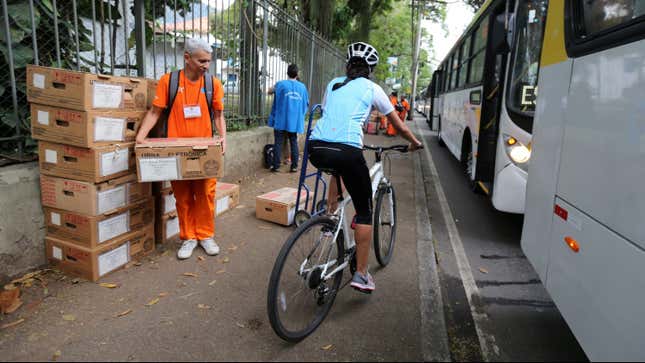 A public cleaner carries an electronic ballot box in Rio de Janeiro.