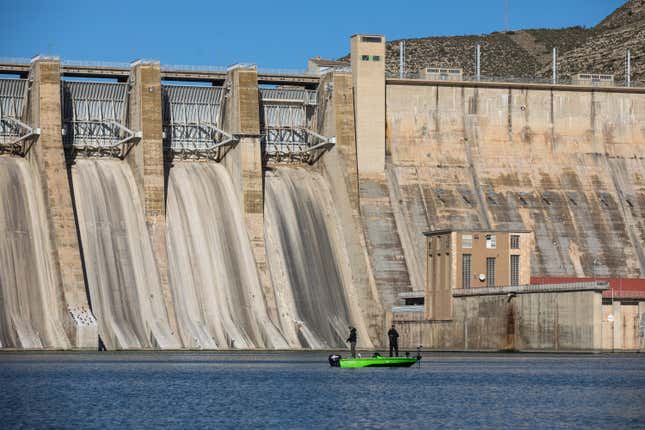 People fishing in front of the dam. 