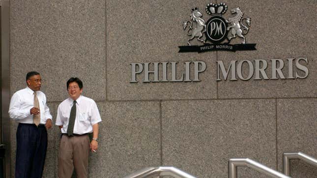 Two workers take a cigarette break outside the then-headquarters of Philip Morris on July 25, 2001 in New York City.