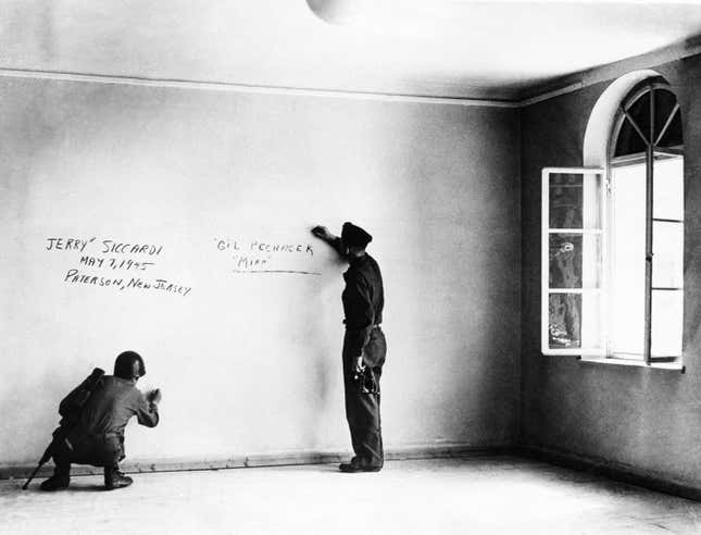 FILE - In this June 14, 1945 file photo a couple of American soldiers write their names on the wall of the bedroom where Adolf Hitler was born in Braunau, Austria. It took nearly a century _ but Adolf Hitler is now formally persona non grata in the town of his birth. Braunau town council's unanimous decision to withdraw honorary citizenship from the community's most infamous son came 78 years after the Nazi dictator was given the title. (AP Photo/Pool/INP)