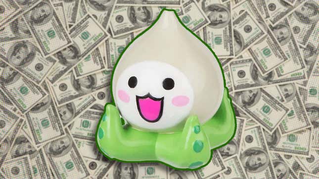 A anime keychain sits on top of a large pile of money. 