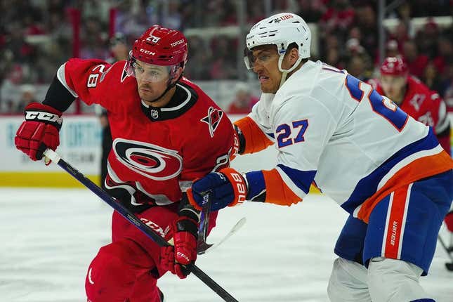 Apr 25, 2023; Raleigh, North Carolina, USA; Carolina Hurricanes left wing Mackenzie MacEachern (28) and New York Islanders left wing Anders Lee (27) battle for position during the third period in game five of the first round of the 2023 Stanley Cup Playoffs at PNC Arena.
