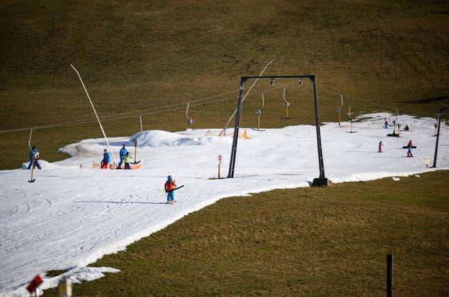 Skiiers on a slope covered in artificial snow in Filzmoos, Austria.