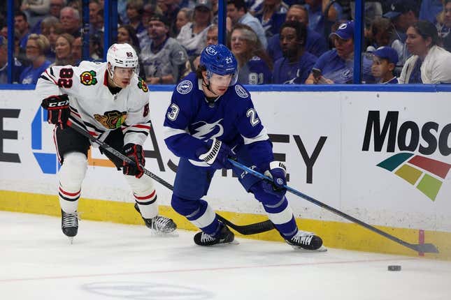 Mar 11, 2023; Tampa, Florida, USA;  Tampa Bay Lightning center Michael Eyssimont (23) controls the puck from Chicago Blackhawks defenseman Caleb Jones (82) in the first period  at Amalie Arena.
