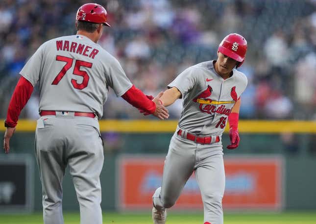 Apr 11, 2023; Denver, Colorado, USA; St. Louis Cardinals short stop Tommy Edman (19) celebrates his solo home run with third base coach Ron Warner (75) in the first inning against the Colorado Rockies at Coors Field.